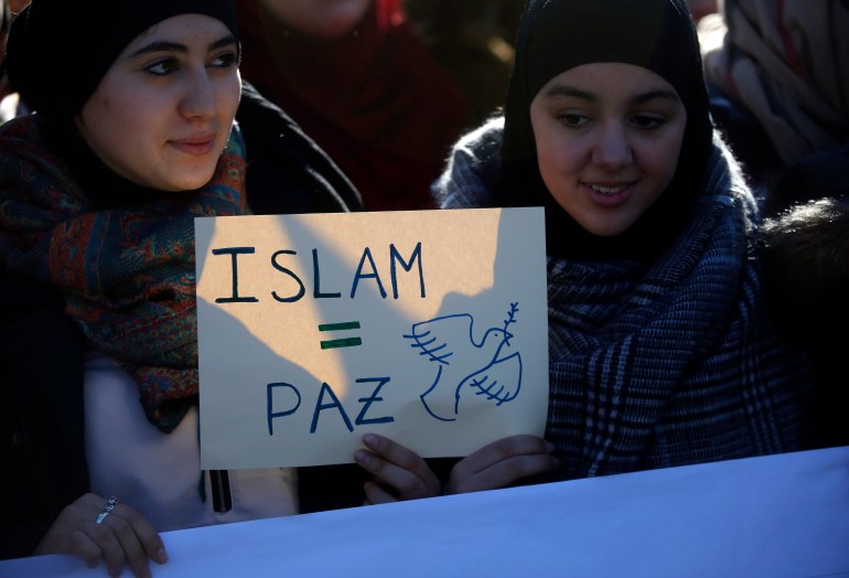 Two young women hold a placard that reads "Islam = Peace" during a rally by members of the Muslim community of Madrid outside Madrid's Atocha train station, January 11, 2015, in solidarity with the victims of a shooting by gunmen at the Paris offices of the satirical weekly newspaper Charlie Hebdo, and against Islamophobia. REUTERS/Juan Medina (SPAIN - Tags: CIVIL UNREST CRIME LAW POLITICS) ATTENTION EDITORS - SPANISH LAW REQUIRES THAT THE FACES OF MINORS ARE MASKED IN PUBLICATIONS WITHIN SPAIN