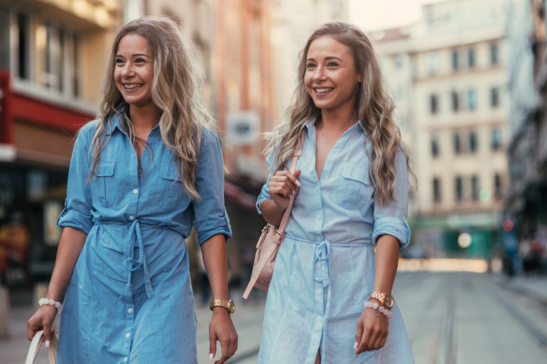 Twins taking a walk on the street in the city