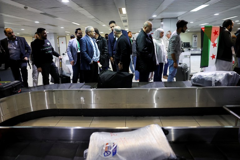 Passengers wait for their luggage at the arrival terminal of Damascus airport, as Qatar Airways becomes the first international airline to announce the return of international flights at Damascus airport after 13 years of its suspension, in Damascus, Syria, January 7, 2025. REUTERS/Yamam Al Shaar