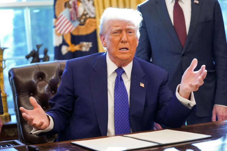 U.S. President Donald Trump signs an executive order in the Oval Office at the White House in Washington, D.C.