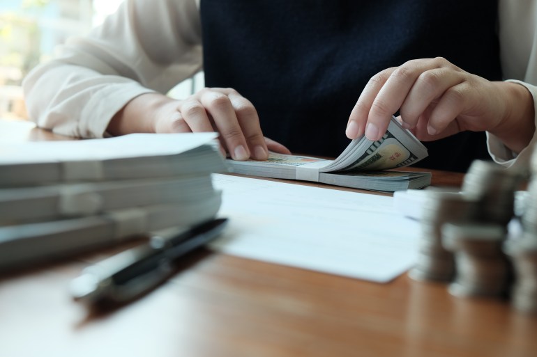 Businessman analyzing investment charts and pressing calculator buttons over documents. Accounting Concept Saving Economy concept.